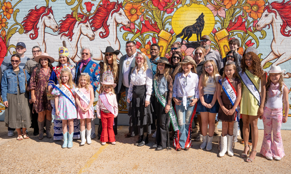 Lainey Wilson, Marty Stuart, sponsors and local supporters gather for a group photo in front of the mural.