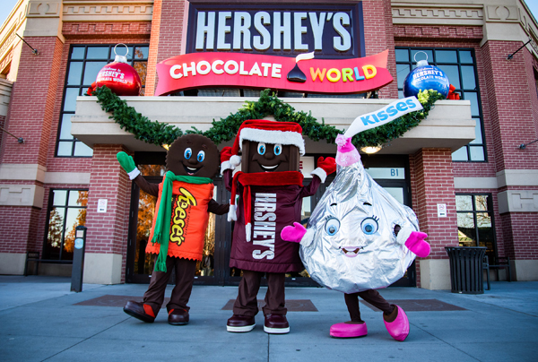 Beloved characters, REESE, HERSH and KISS get into the holiday spirit outside the entrance to Hershey’s Chocolate World.