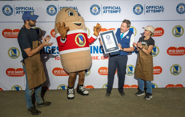 (Left to right) Potato Days Founder Thomas Watson, Spuddy Buddy, Guinness World Records adjudicator Michael Empric, and Jeweldean Hull celebrate after officially setting a new Guinness World Records title for the largest serving of French fries at Boise Potato Days in Boise, Idaho, on Friday, Oct. 2, 2026. The record-setting serving weighed 1474 pounds.