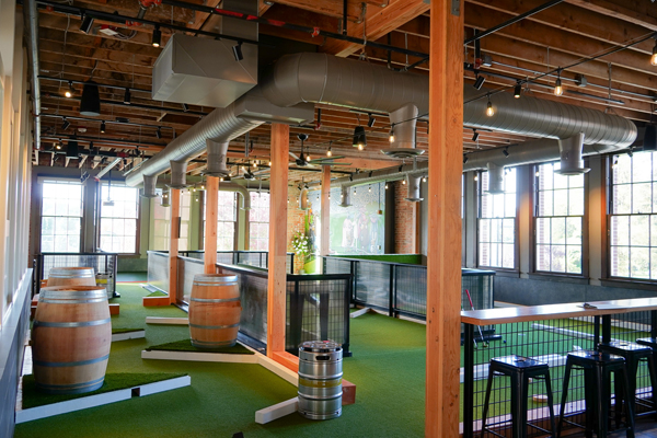 The links-style mini golf course at Flatstick Pub Woodinville runs through the second floor of the restored Old Woodinville School, a brick schoolhouse that dates to 1909, in Woodinville's Schoolhouse District.
